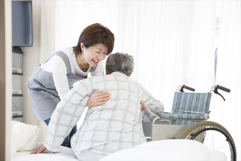 高齢者を抱きかかえる介護士